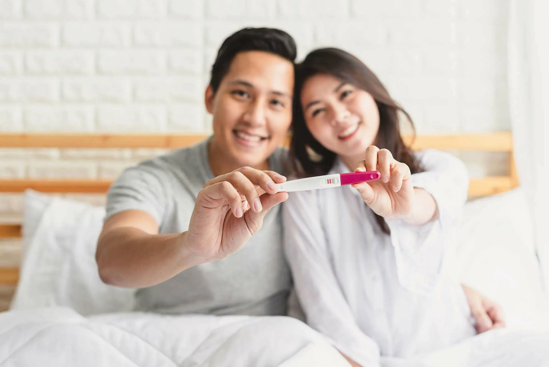 A joyful couple holding a positive pregnancy test